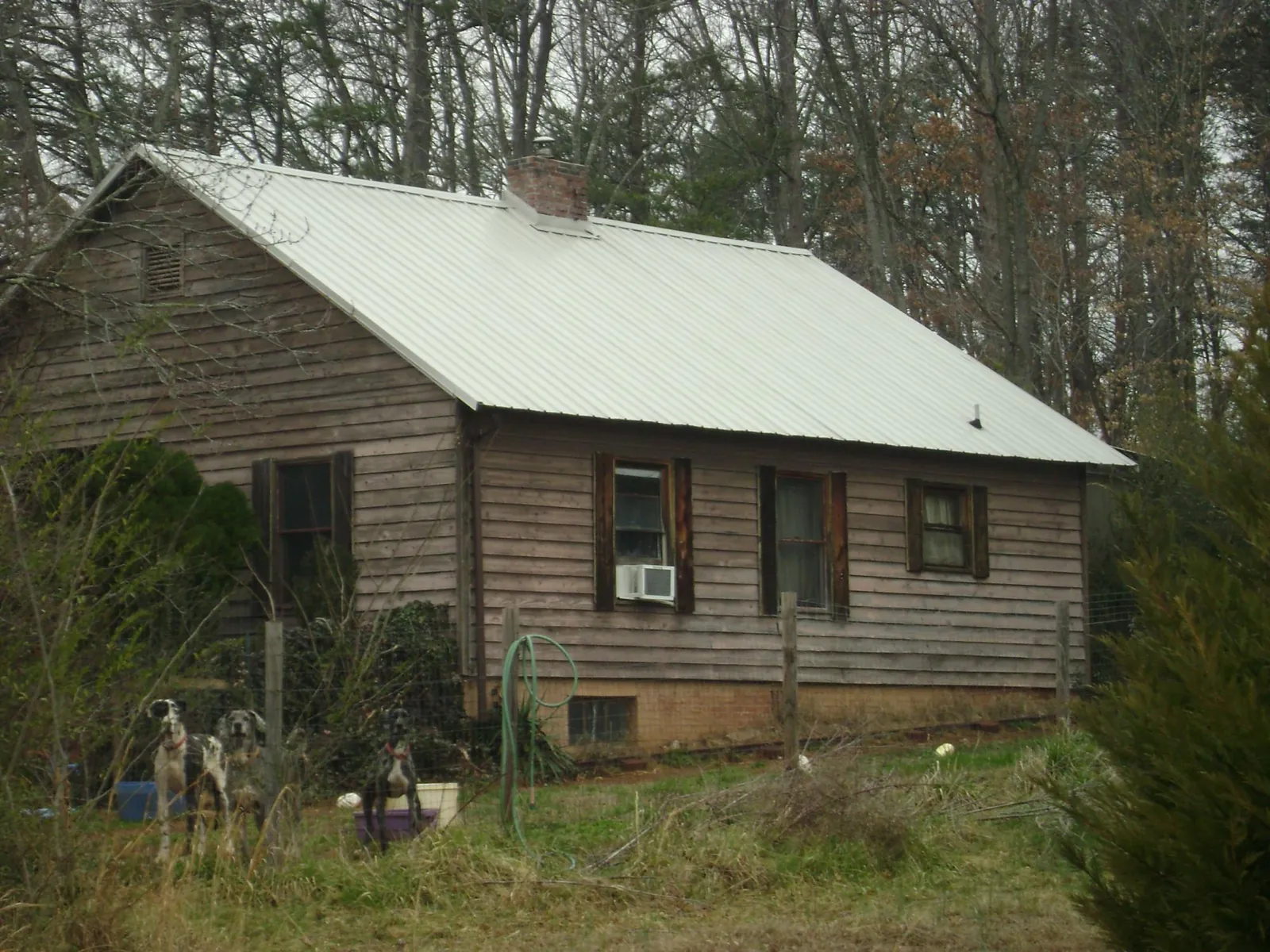 White metal roof on an old wood sided farmhouse, from a Metal Roof Installation job in Farwell
